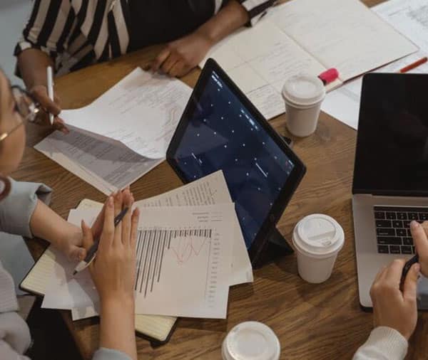 People-sitting-at-a-desk-taking-notes